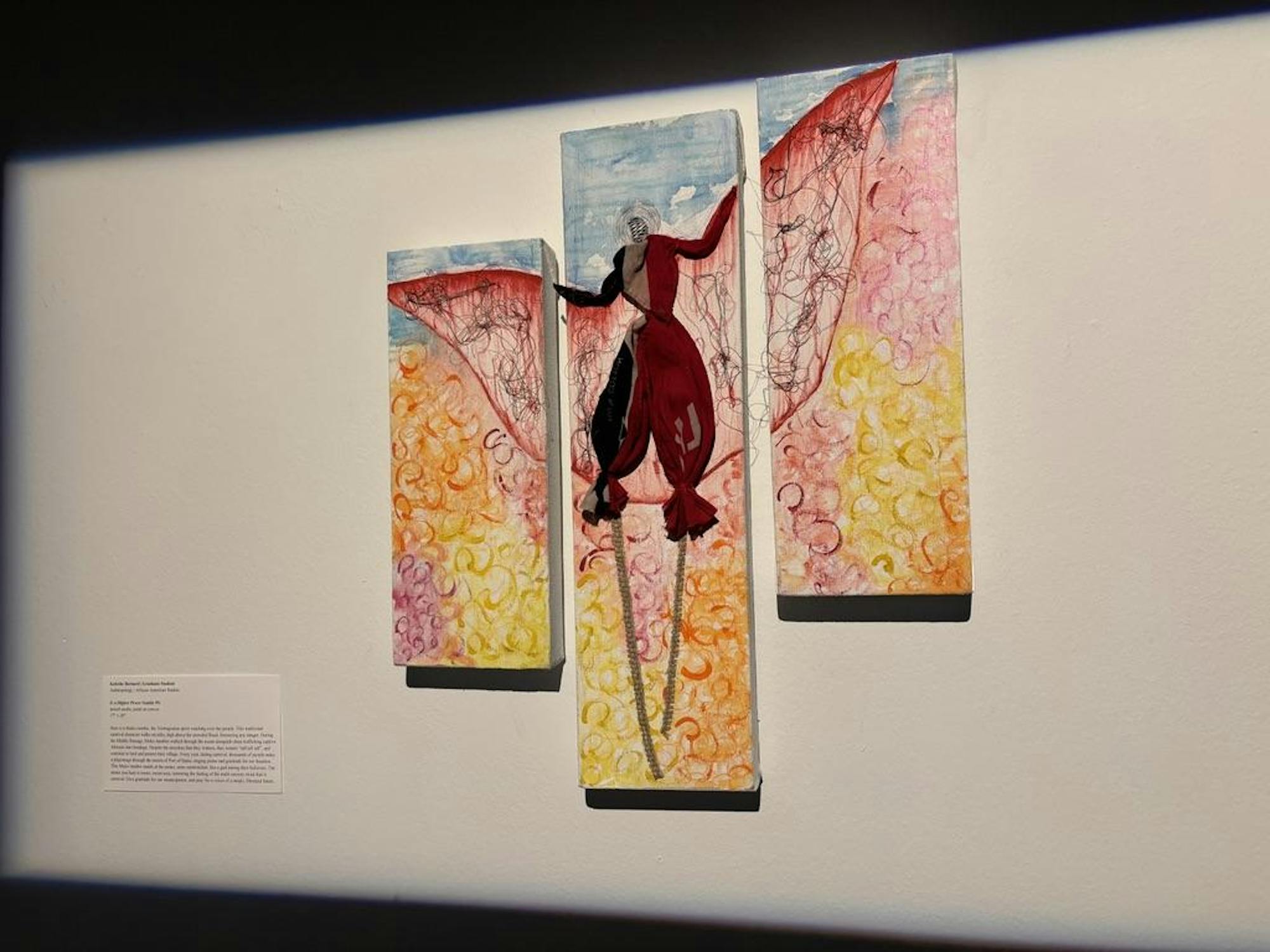 Three connected paintings show a figure on stilts in bright colors.