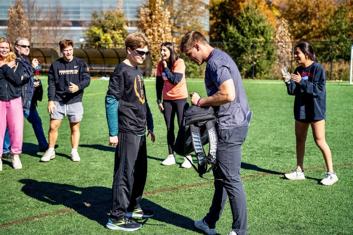 People standing on a field, conversing.