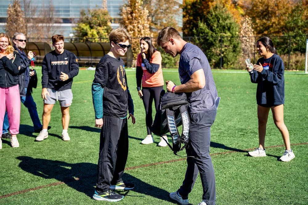 People standing on a field, conversing.