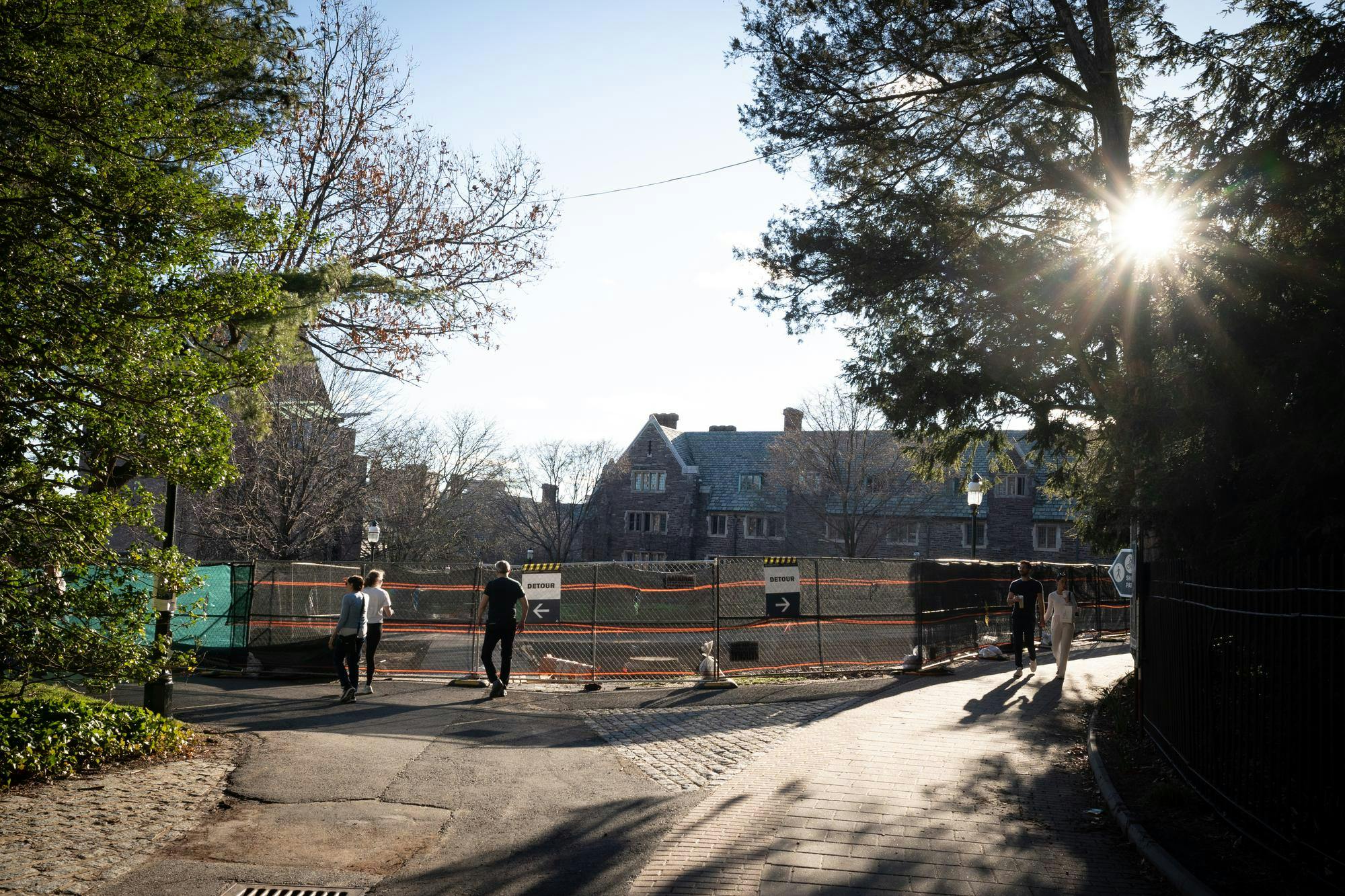 Path blocked off with metal fences and 2 detour signs.