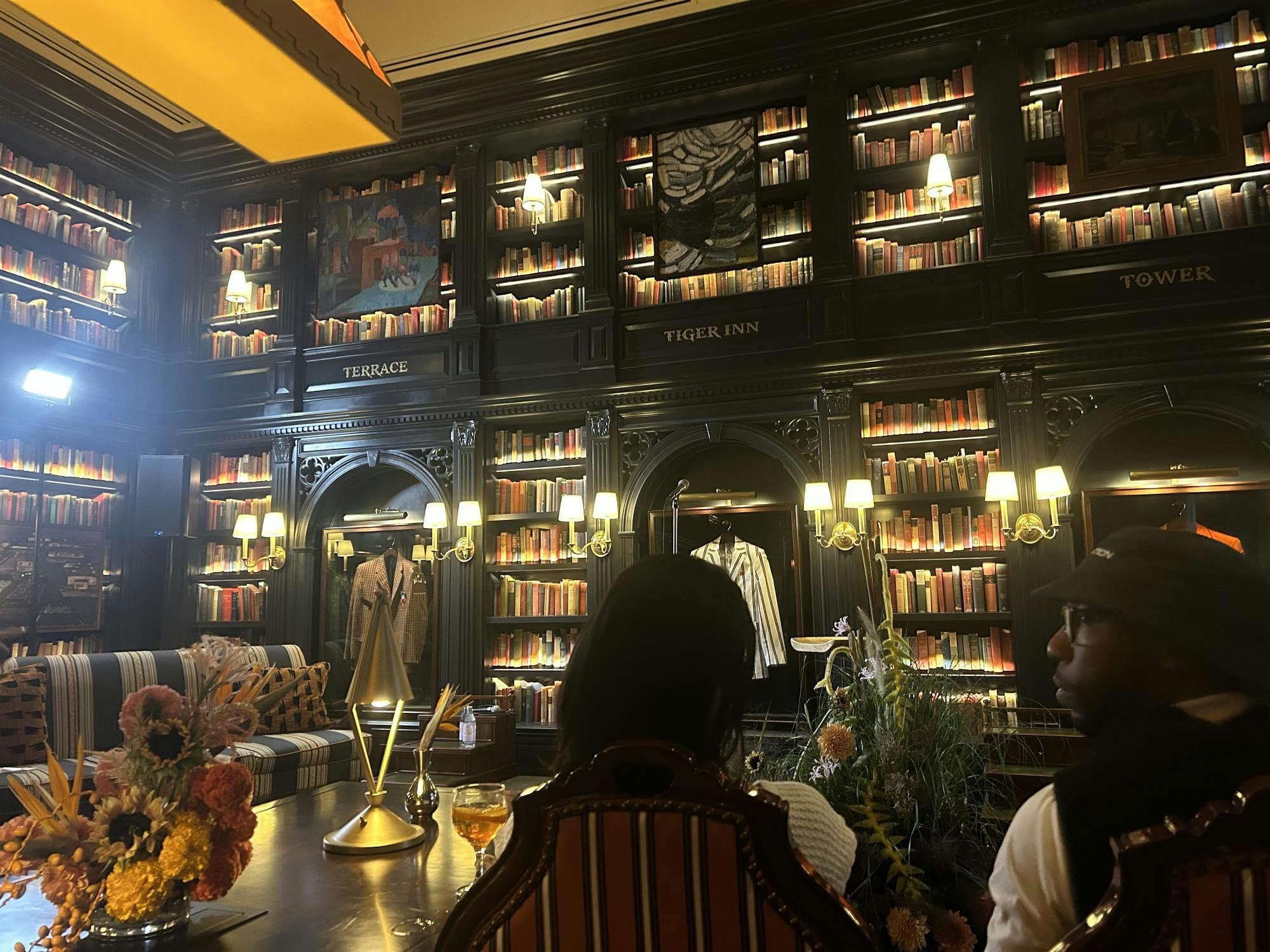 Two people sit in the dark lobby of a hotel