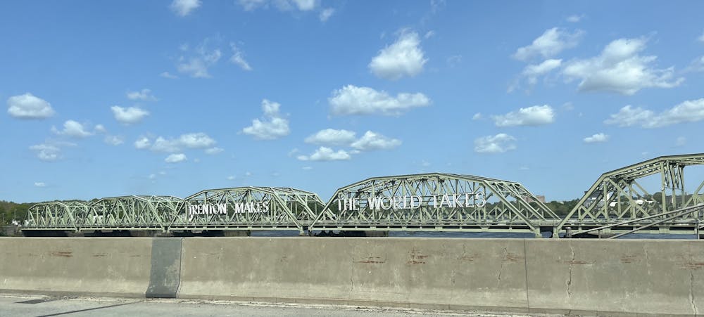A green bridge with the text ""Trenton Makes The World Takes" in white.