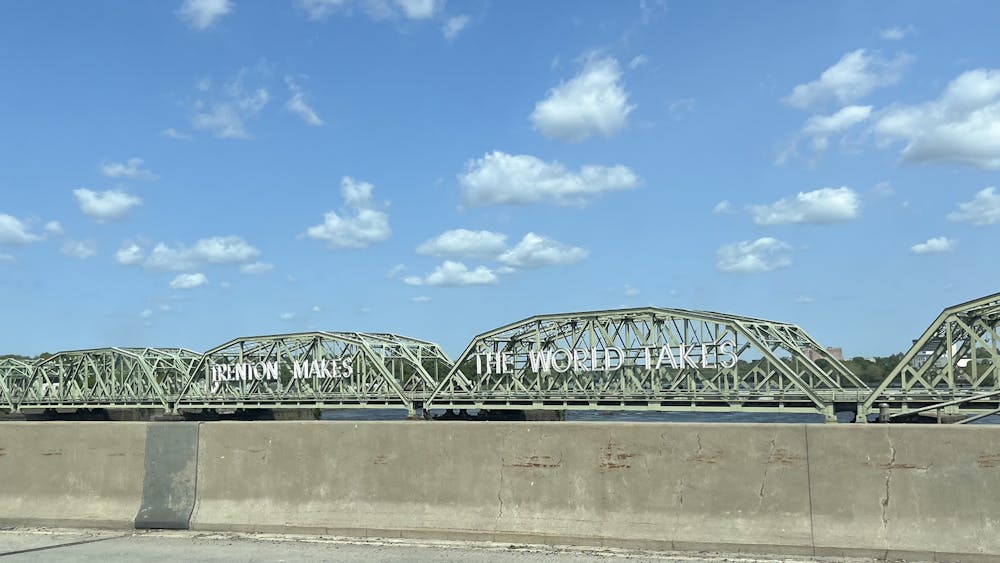 A green bridge with the text ""Trenton Makes The World Takes" in white.