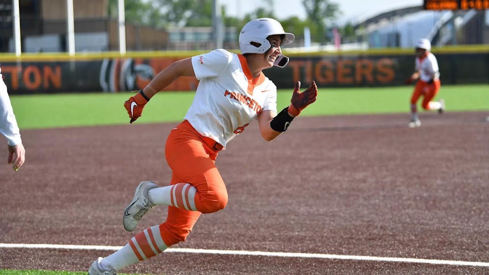 A women running on a softball fielding where orange and white. 