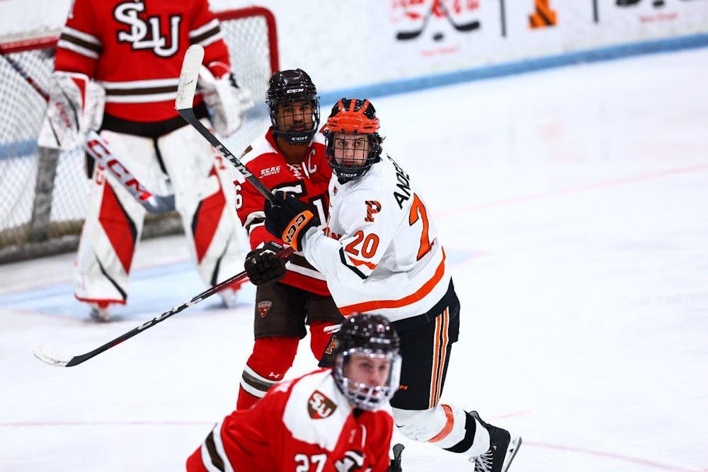 Hockey player in white jersey fights for positioning with player in red jersey.