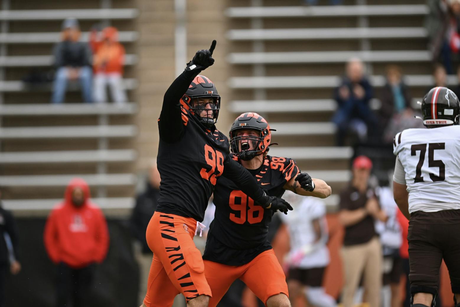 Two players in black jerseys celebrate, with one pointing to the air. 