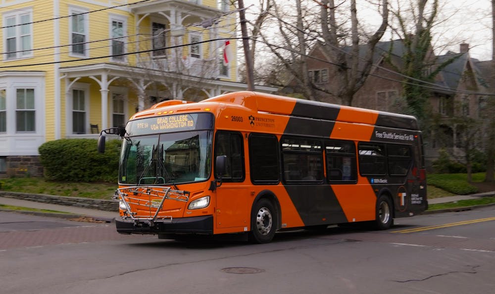 Orange TigerTransit bus traveling near a residential area.