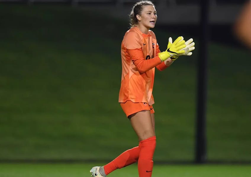 Woman in orange playing goalkeeper.