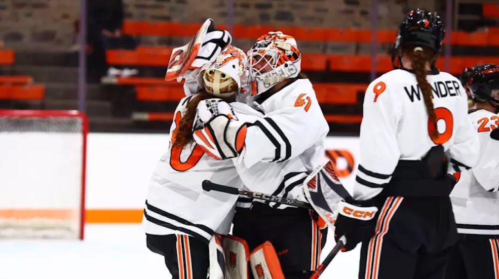 Two Princeton women's hockey players hugging.