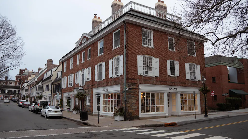 A brick building with the clothing store "Nic+Zoe" stands on the corner of a street in Palmer Square.