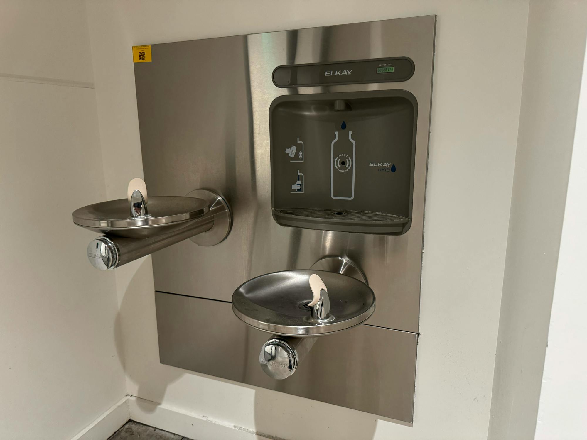 Two shining, chrome water fountains.