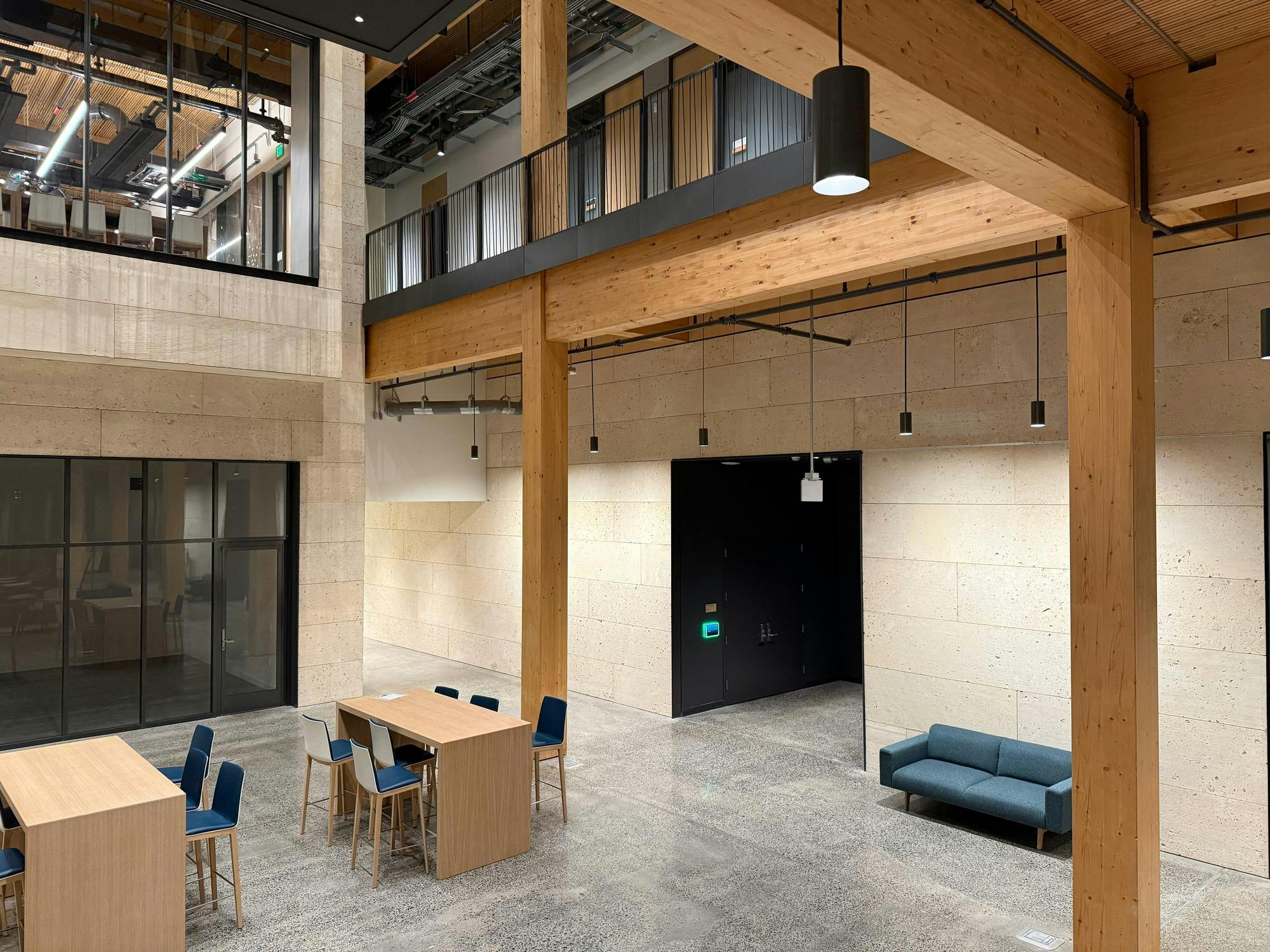 Room with beige walls and wood tables and wood beams.