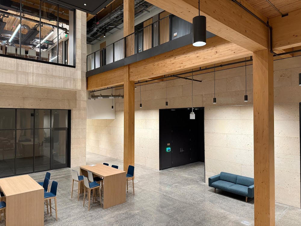 Room with beige walls and wood tables and wood beams.