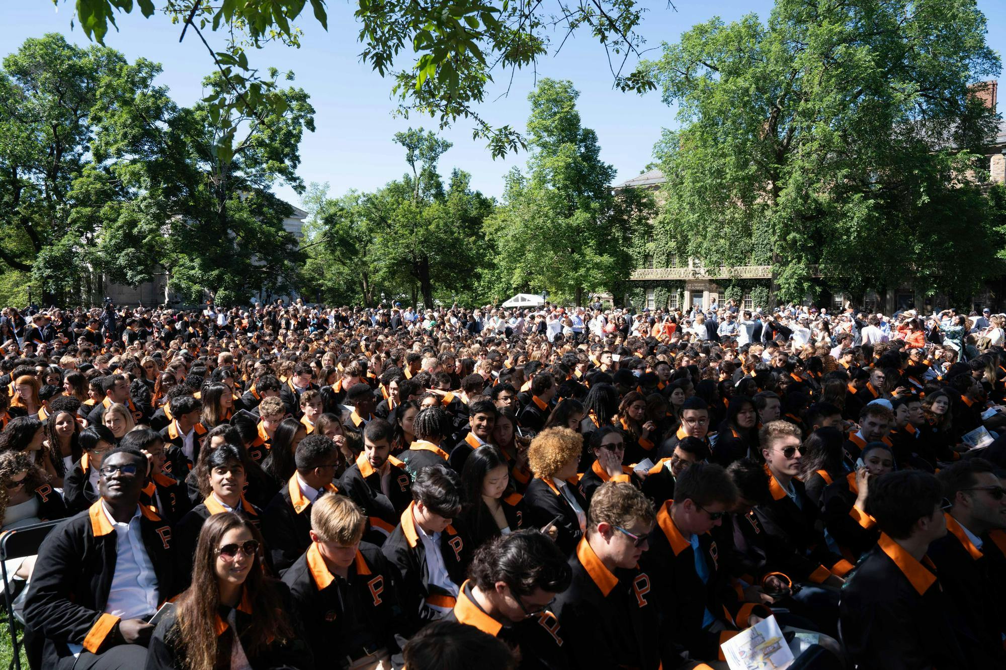 Several&#x20;hundred&#x20;people&#x20;sit&#x20;in&#x20;a&#x20;field.