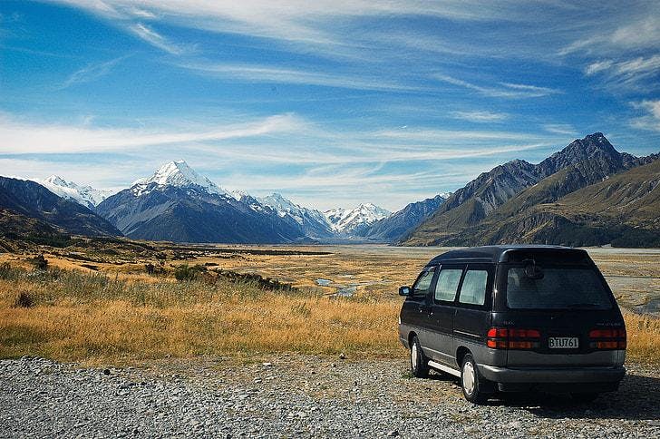 Car parked in front of a scenic view.