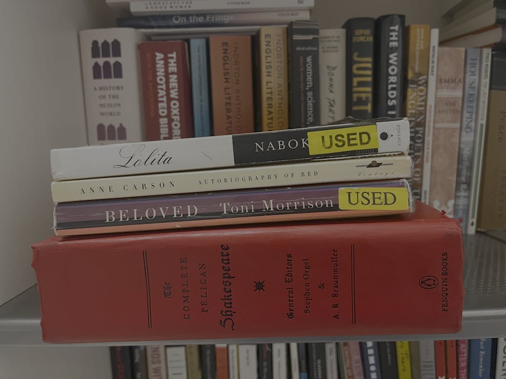 Four books are facing spine-outward on the top shelf of a white bookshelf.