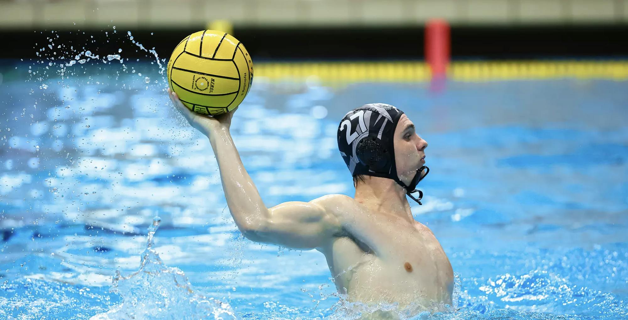 Men’s water polo player takes a shot in a game.