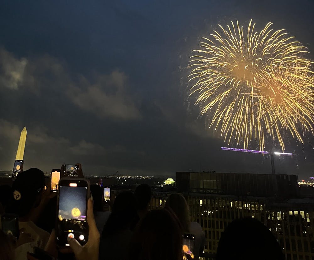 View of fireworks from on top of a roof.