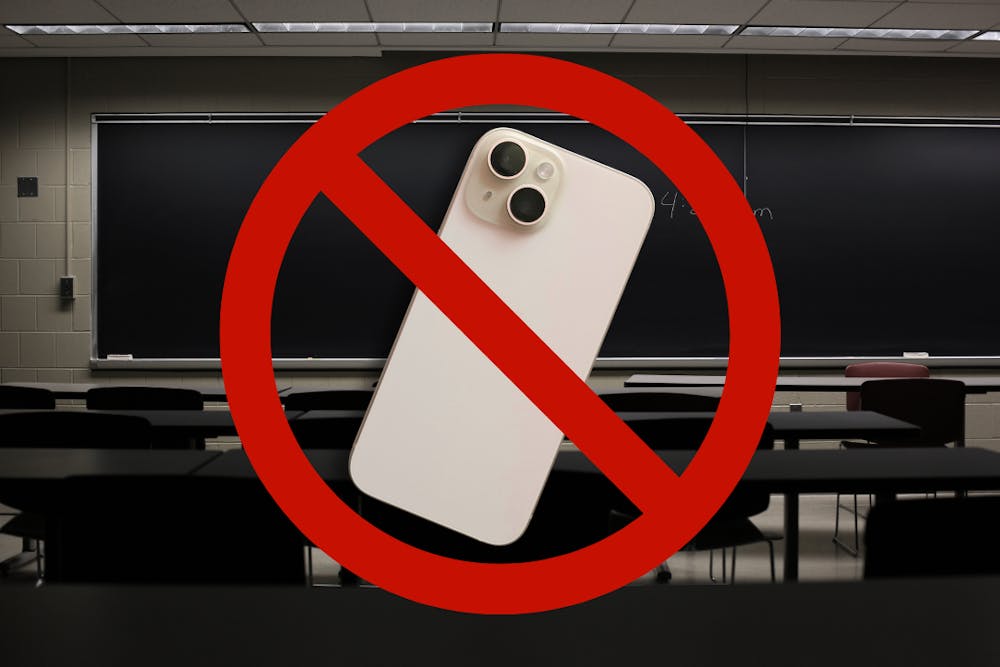 A standard classroom with a chalkboard. There is a cellphone with a red cross across it.