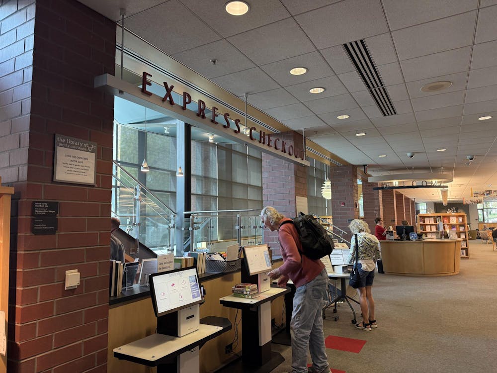 A man checks out a book at the self-check kiosk.