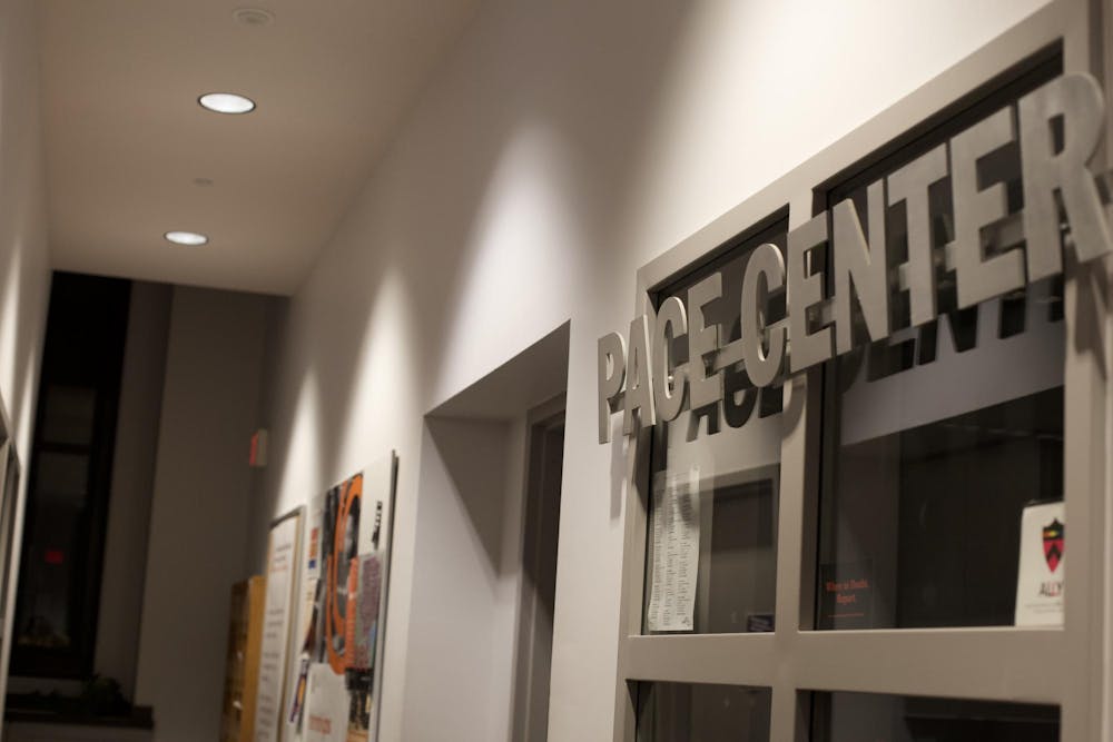 Metal sign reading "Pace Center" above a dorm frame in a dimly lit hall way.