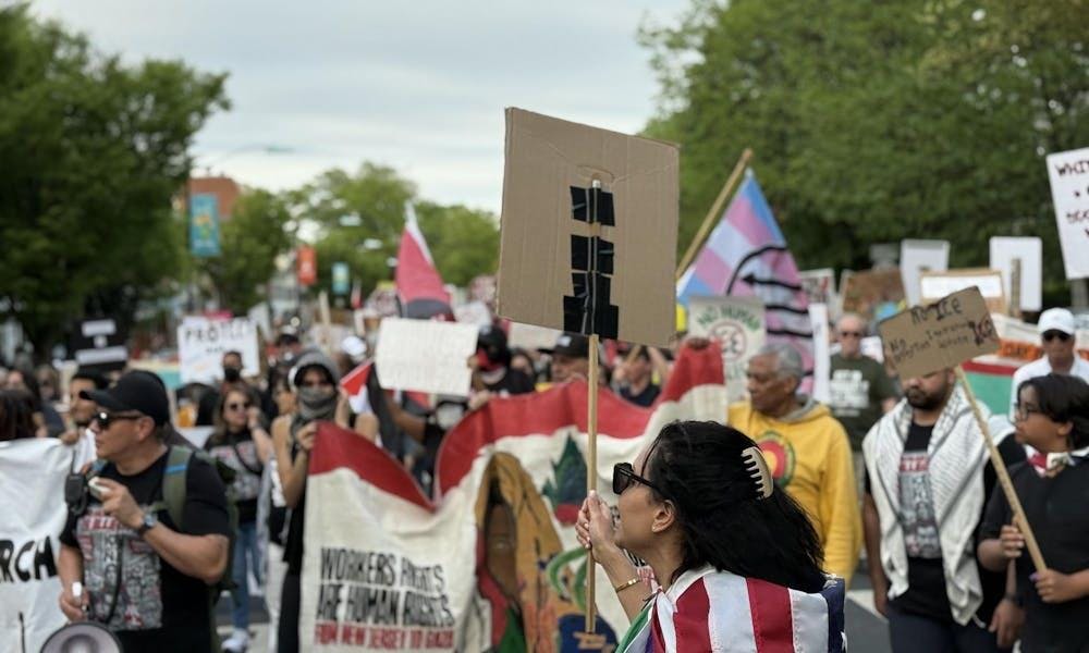 Una multitud de personas marcha por una calle. Llevan pancartas.