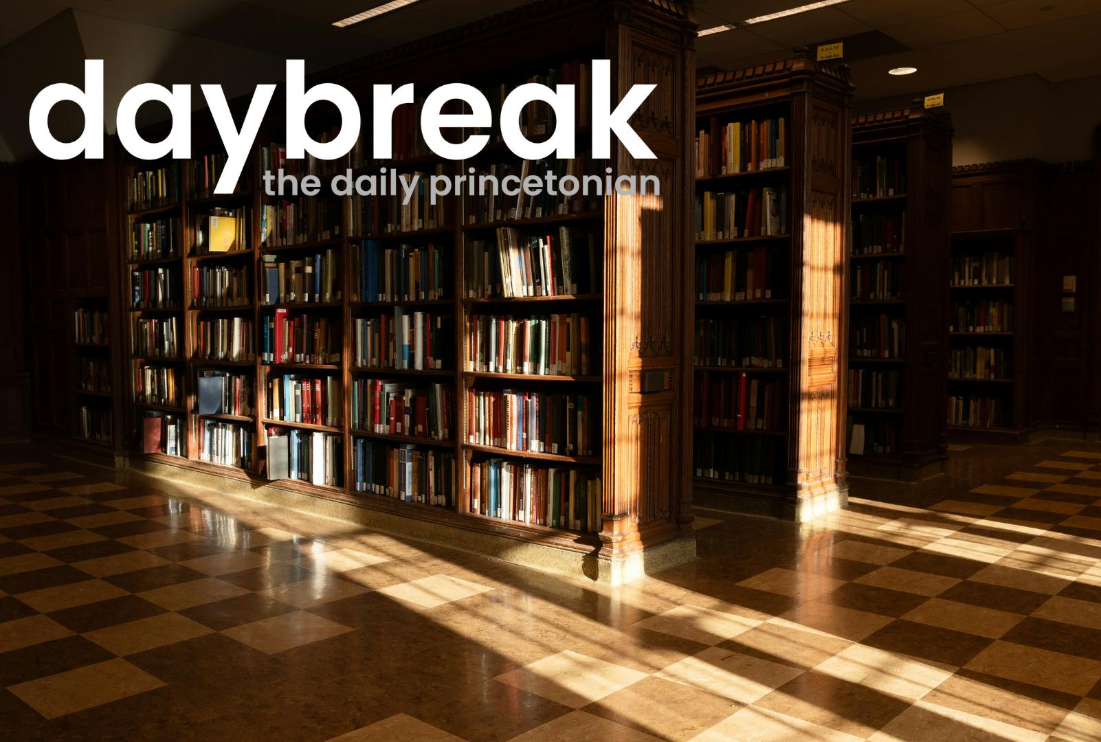 Photo of wooden library bookshelves, a checkerboard wooden floor, light from windows shines onto them. In the top left, a logo that says "daybreak: the daily princetonian"