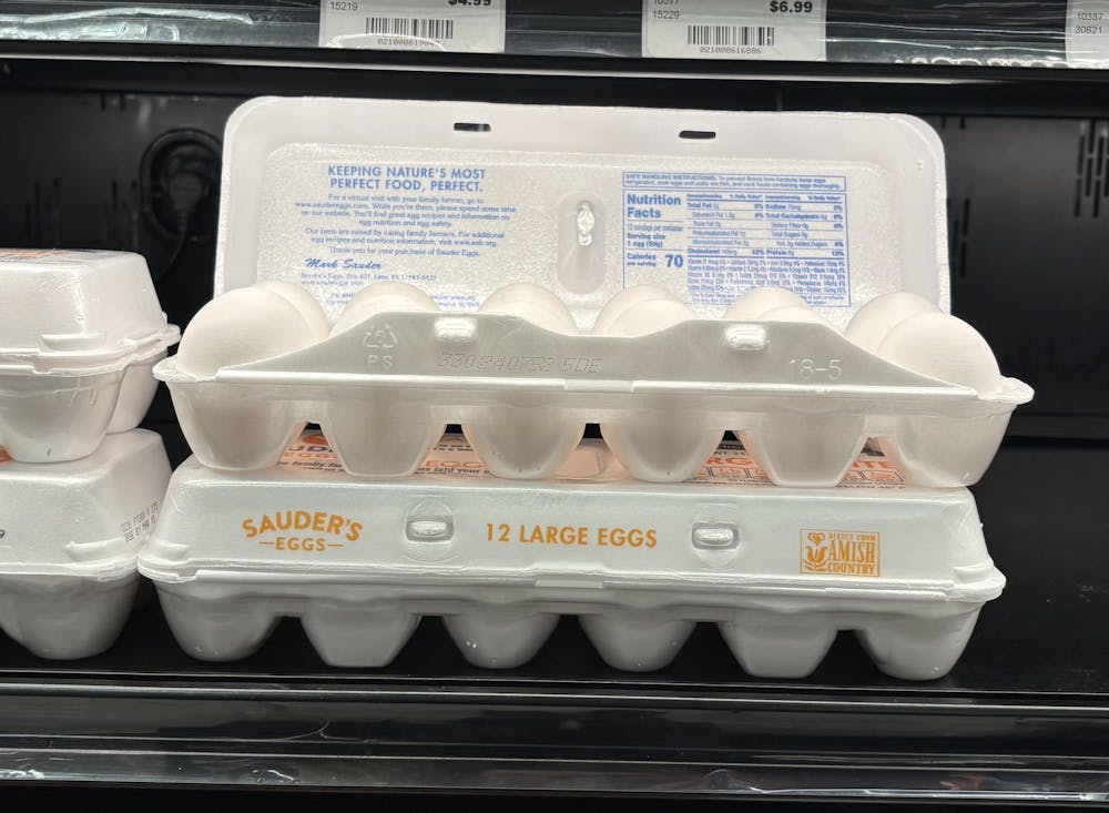 An open egg carton sits on a shelf in a grocery store. 