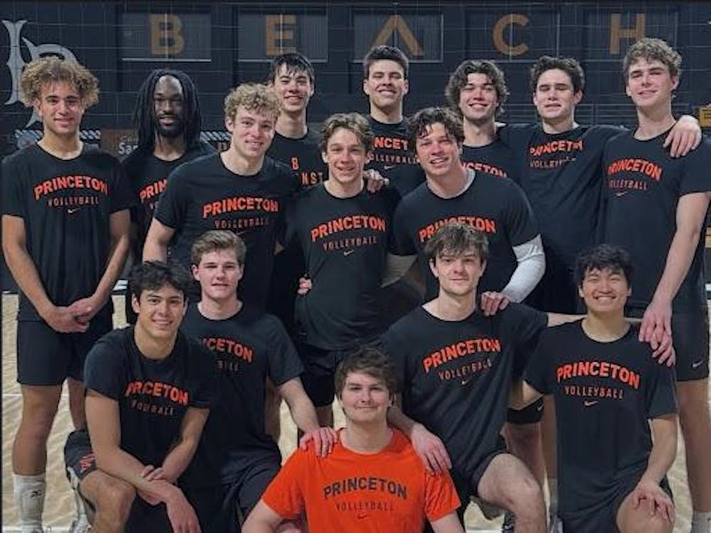 Men's volleyball team in black shirts and shorts on a volleyball court.