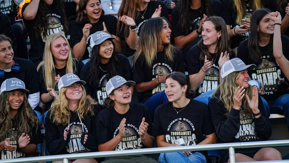 Group of players laughing don shirts that read "women's soccer tournament champs." 