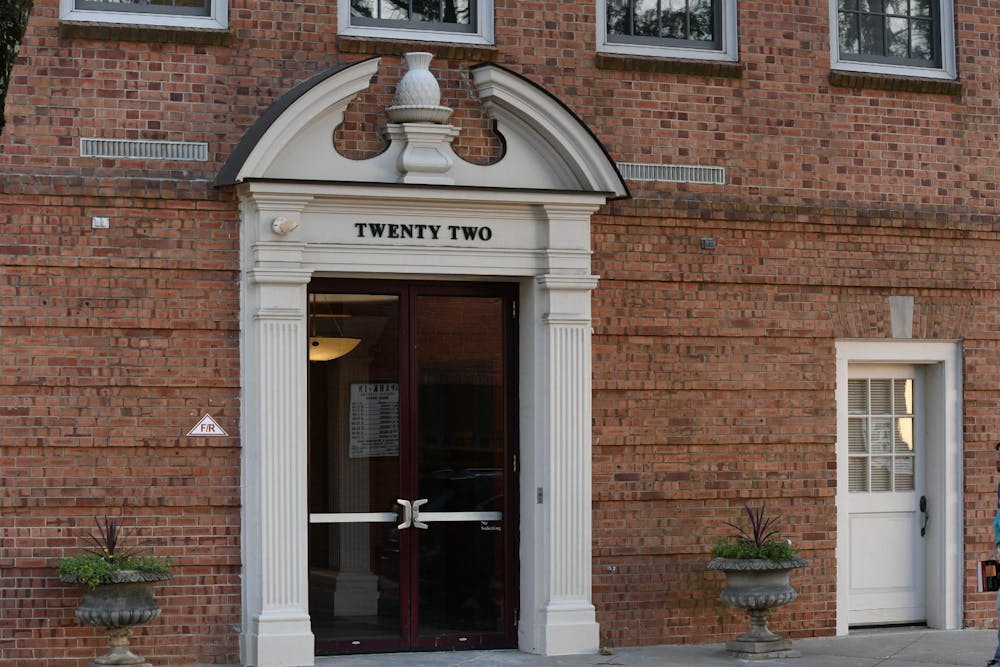 Red brick building with a large, ornate, and white entry way. The top of the entry way reads "twenty-two."