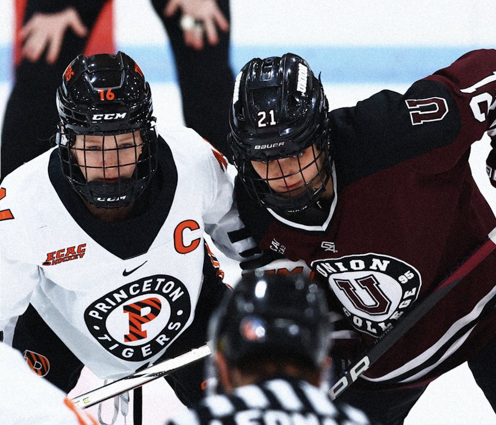 Princeton hockey player and Union hockey player stare downwards while next to each other