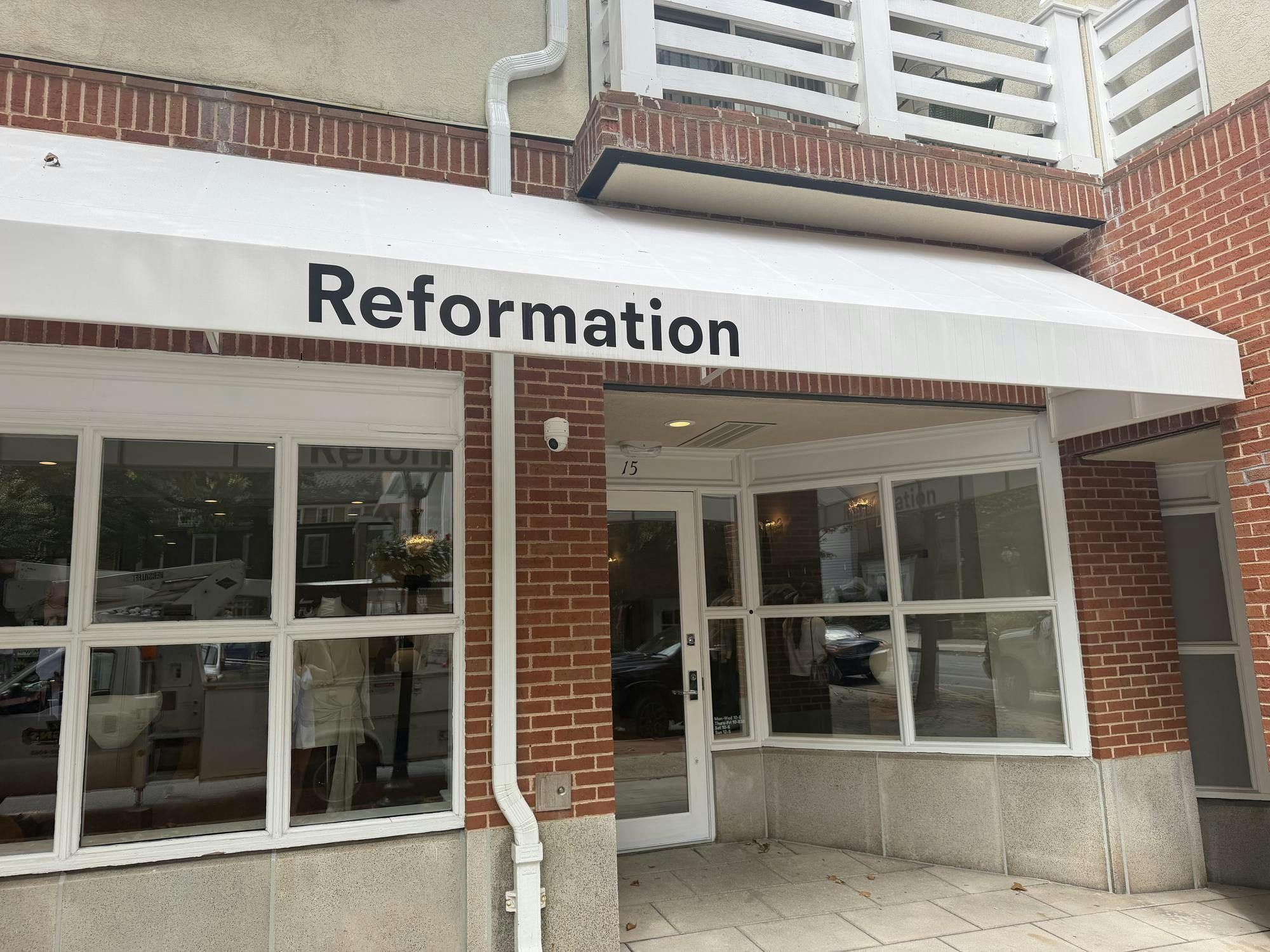 A storefront with white awning labeled "Reformation" in black letters set in a red-brick building. 