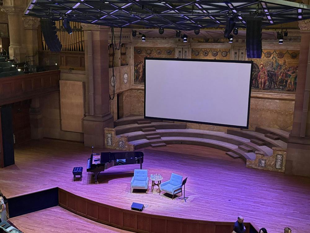 The stage of Richardson Auditorium is cast in purple lighting.