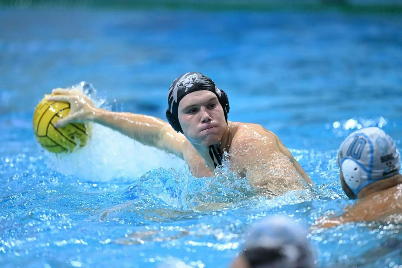 Man in a black swim cap throws a yellow water polo ball.