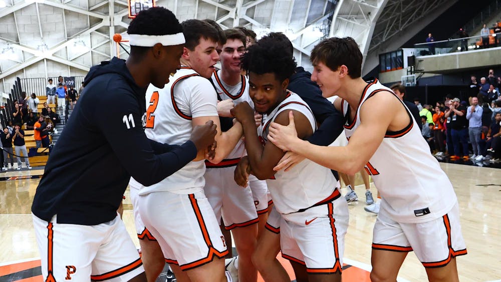 Basketball players in white uniforms huddle around each other.