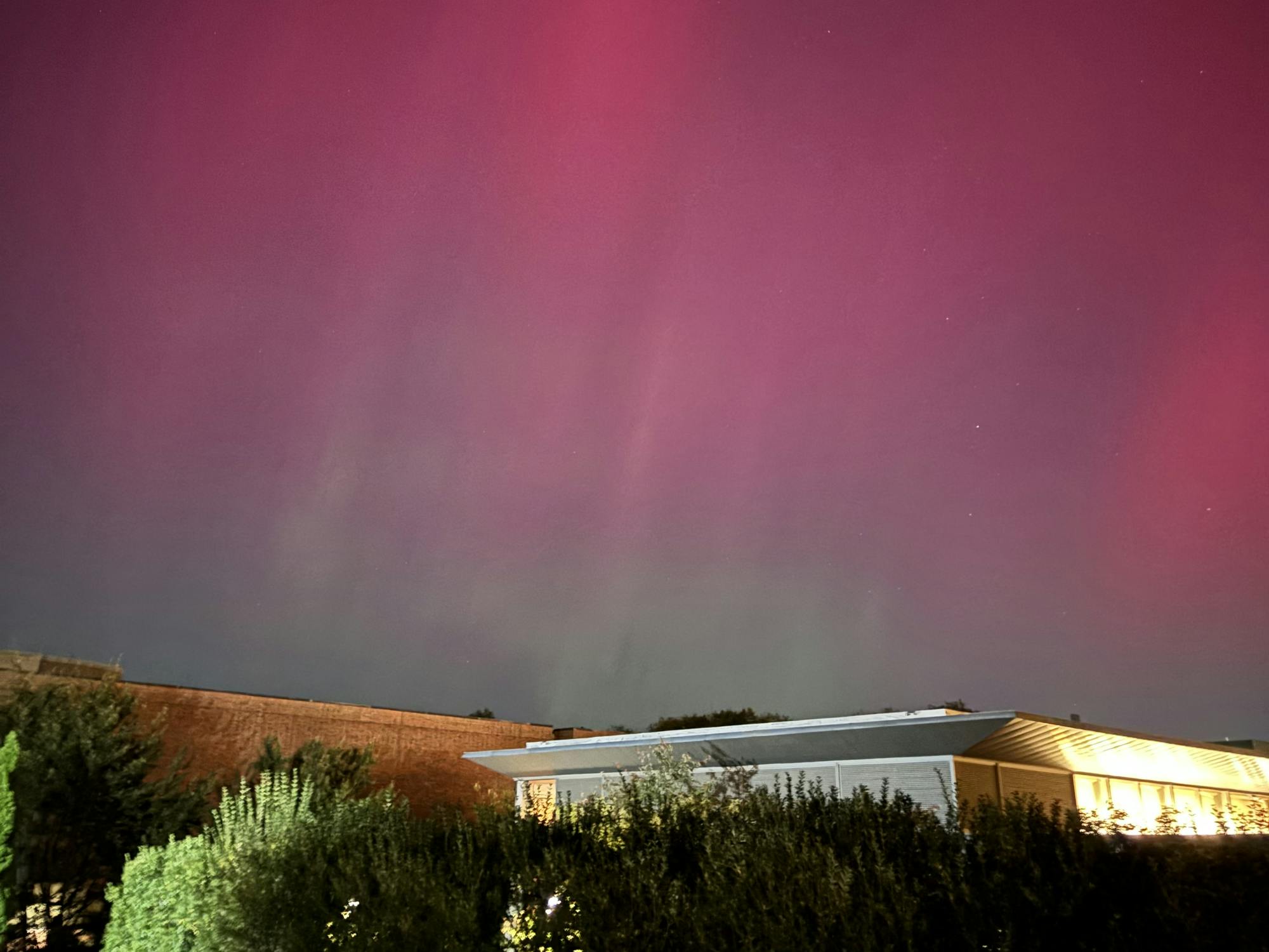 Pink into green ombre colors the sky above the Genomics building