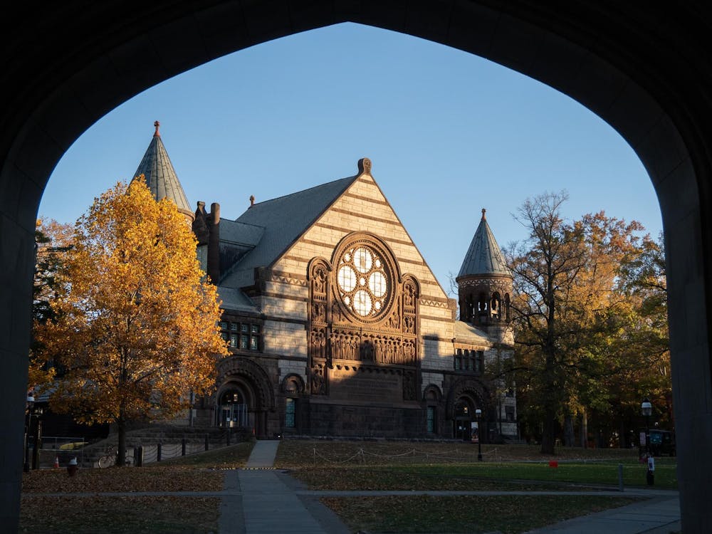A large concert hall surrounded by trees with yellow leaves.