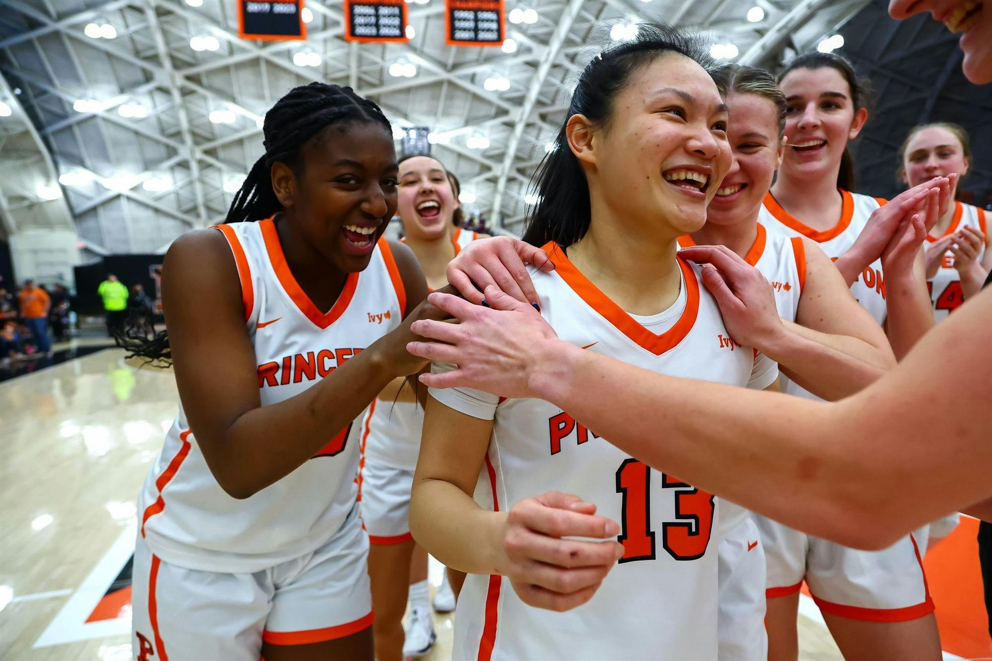 Basketball team celebrating and smiling.