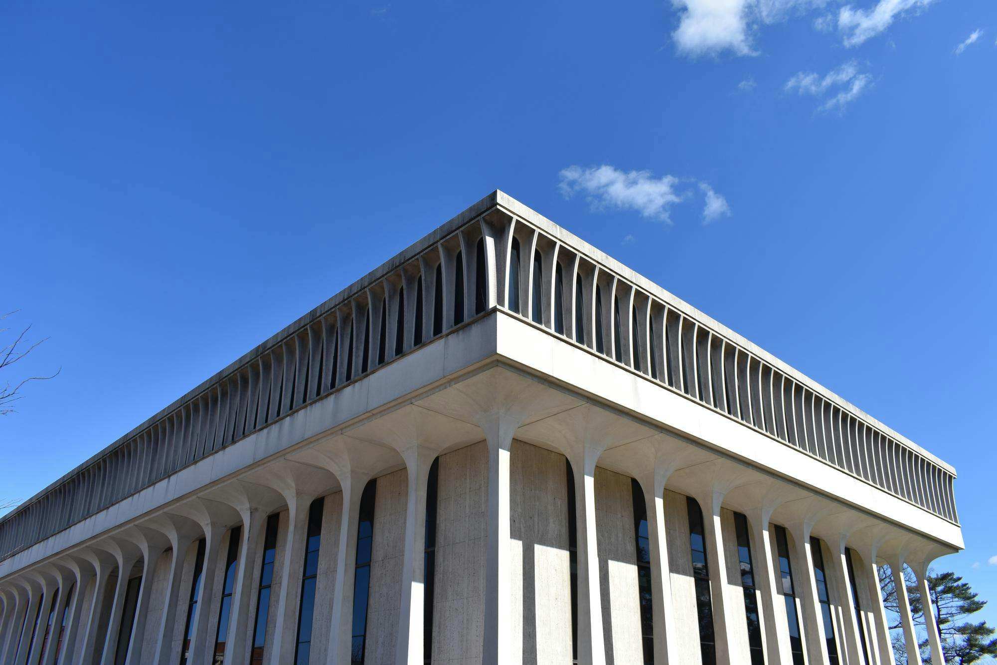 A picture of a white building with columns against a blue background. 