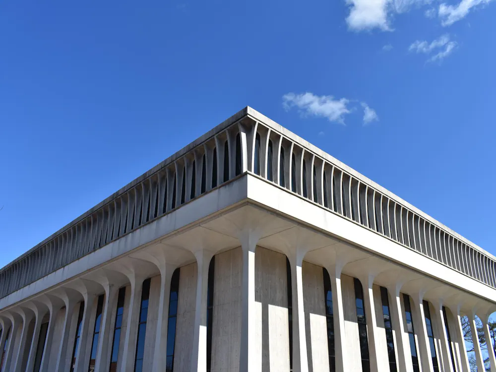 A picture of a white building with columns against a blue background.