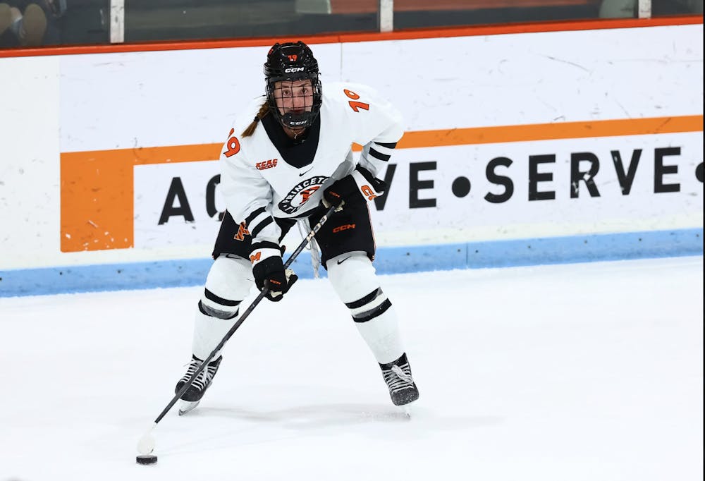 Woman in ice hockey gear on ice.