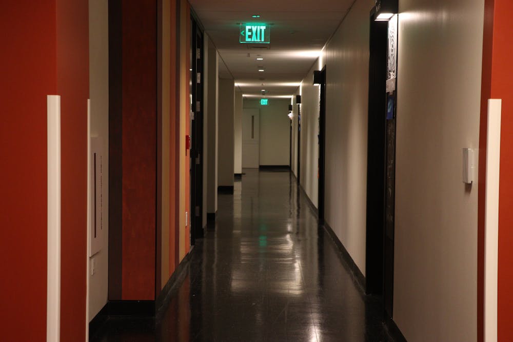 A hallway with red and white walls and grey linoleum floors.