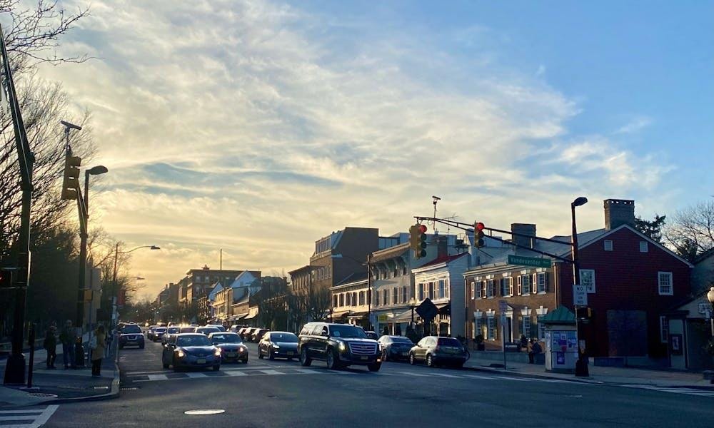 A photo of a town intersection under yellow-orange sunset skies.