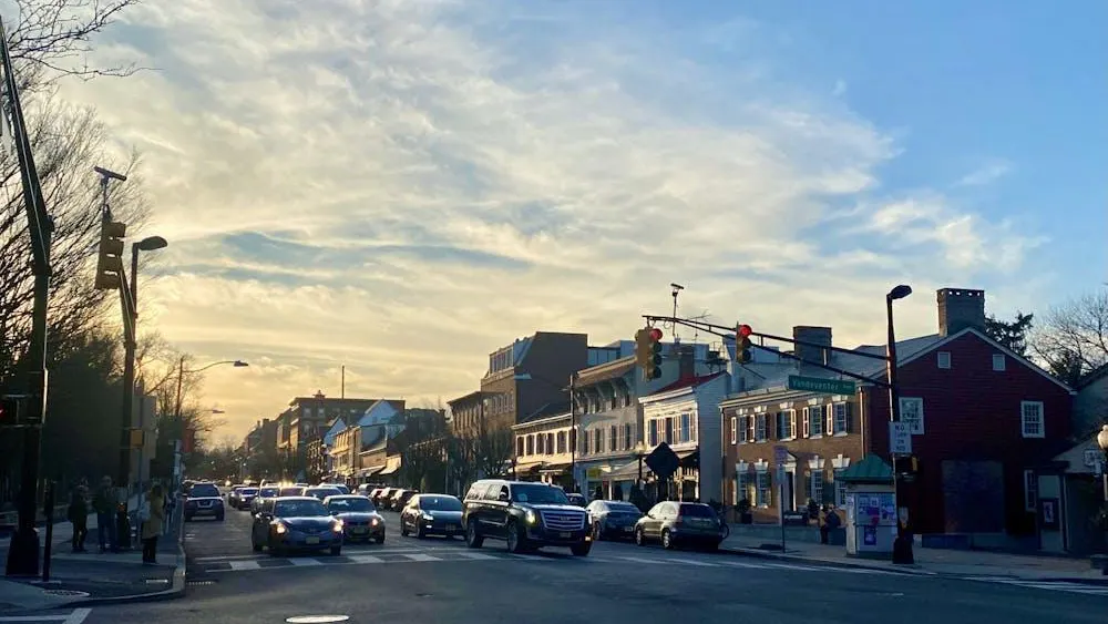 A photo of a town intersection under yellow-orange sunset skies.