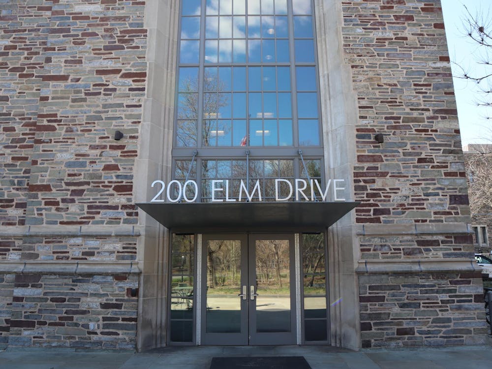 A stone building with large letters above the doorway spelling, “200 Elm Drive”