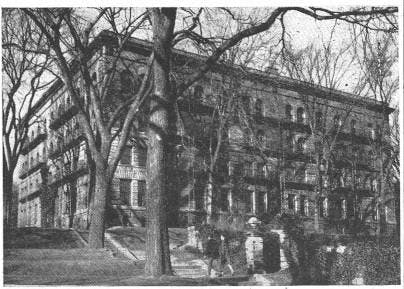 A black and white photograph of the edifice of Brown Hall, a square stone dormitory.