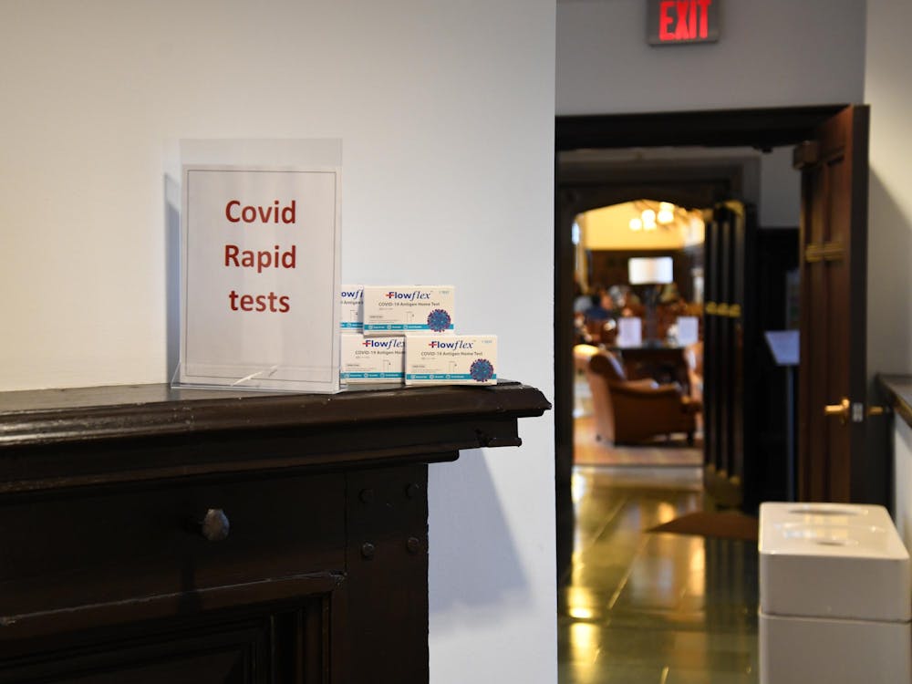 A sign reading "COVID Rapid Tests" next to several boxes of "Flowflex" COVID kits.