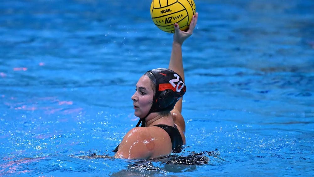 A women in the water holding a water polo ball. 