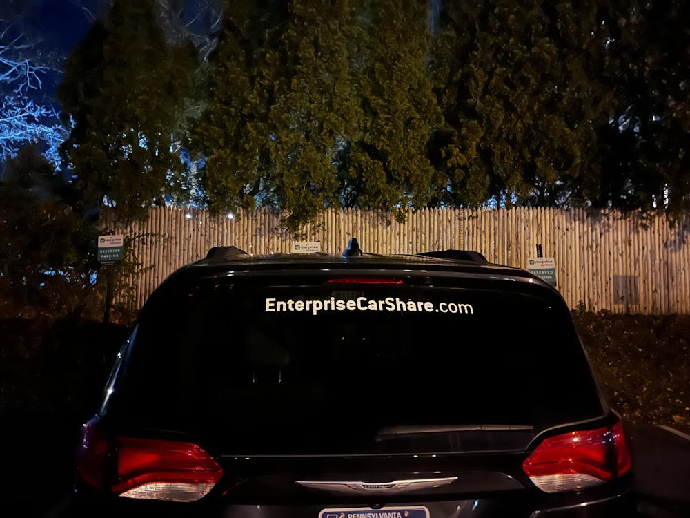 Black van parked at night. Enterprise sticker with website on rear windshield. 